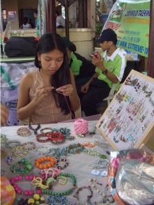 A female crocheting beaded accessories